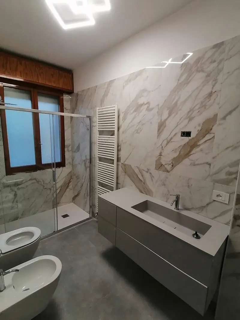 Bagno nuovo con rivestimento in marmo e doccia a filo pavimento