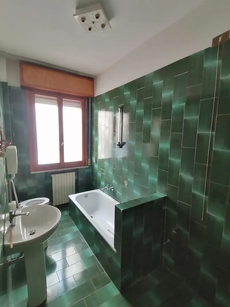 Vecchio bagno con piastrelle verdi prima dell'intervento